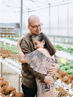 older couple hugging in greenhouse